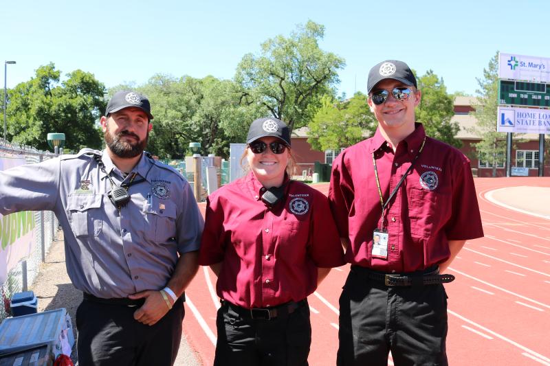 Photograph of three volunteer for the Mesa County Sheriff's Office working at event held at the Lincoln Park track