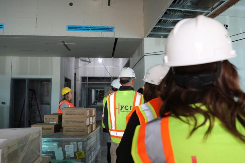 Back of people's heads walking through building under construction. 