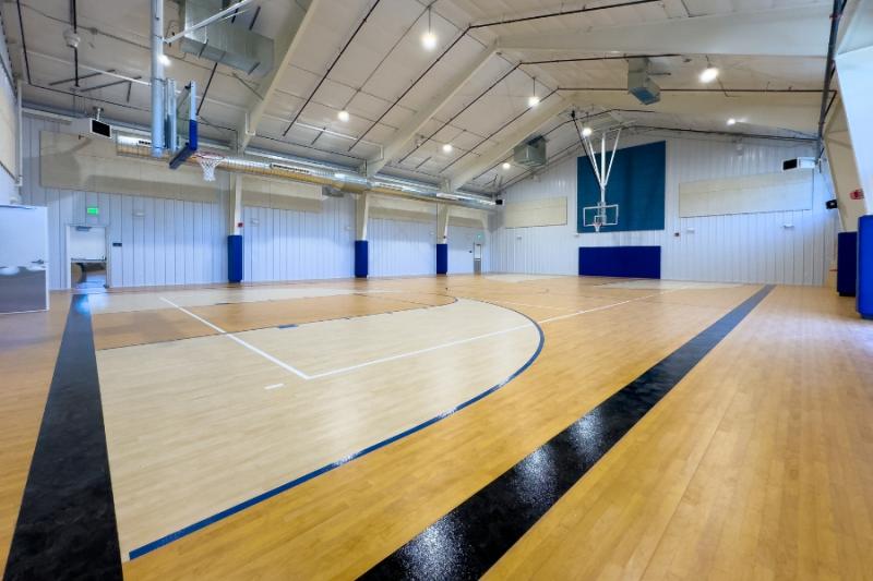 Large indoor basketball court with two hoops. 