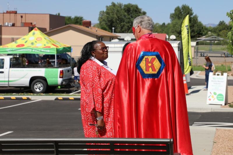 Woman talking to man in super hero costume. 