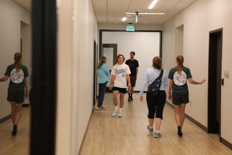 Several people walking in hallway. 