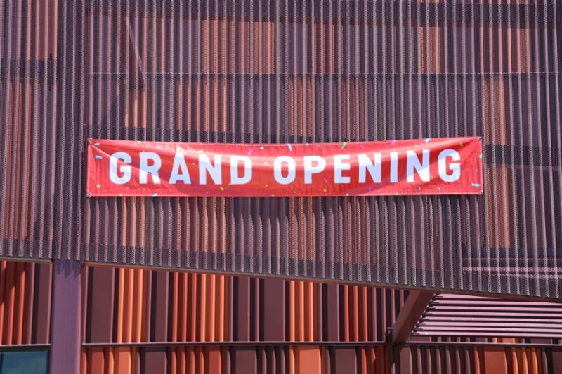 Orange and purple building with red and white sign reading, "GRAND OPENING."