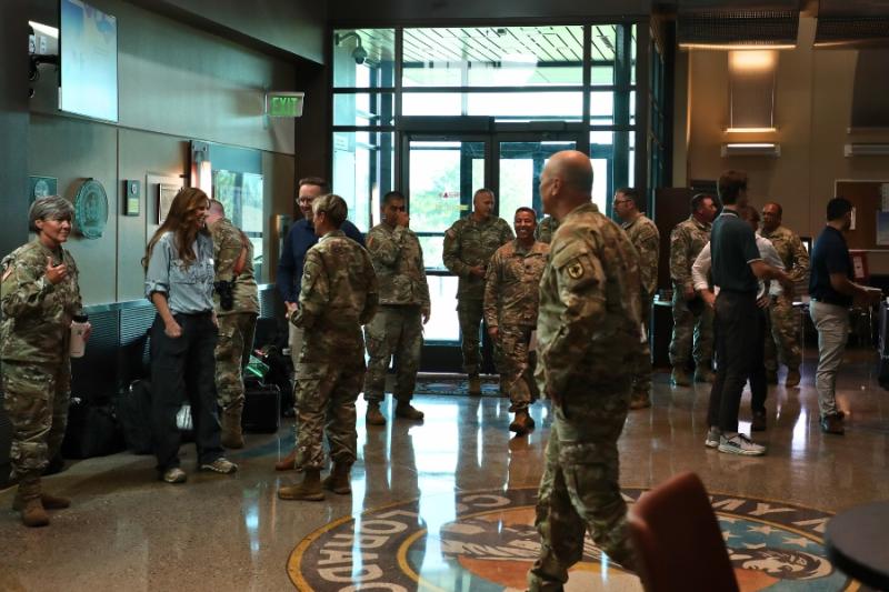 Many Army soldiers standing in a building.