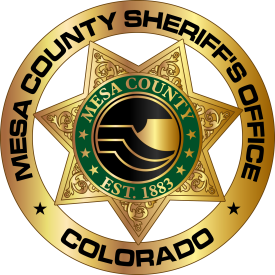 Logo for Mesa County Colorado Sheriff's Office Established 1883 with a circle with thick gold border, star law enforcement badge with Mesa County logo which is a circle with a gold border, three gold lines representing mountains, and a gold mountain shape in the center
