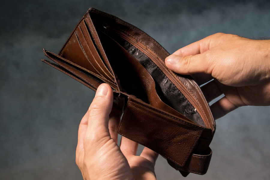 A person holds open an empty wallet