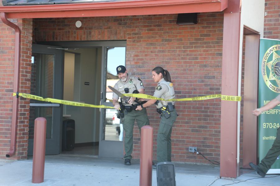 1 female and 1 male employee of the Mesa County Sheriff's Office cut crime scene tape on new Clifton substation. 
