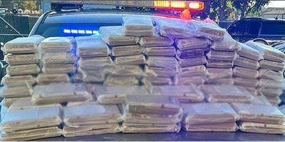In a photo provided by the Colorado State Patrol, nearly 300 pounds of cocaine is stacked on a patrol car. Two men were arrested after their vehicle was stopped Monday around 3:30 a.m. on Interstate 70 near milepost 27.