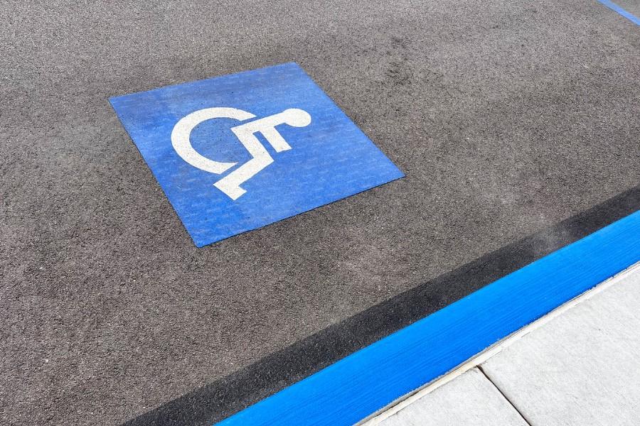 paved parking spot with blue handicap square and white wheelchair painted in it