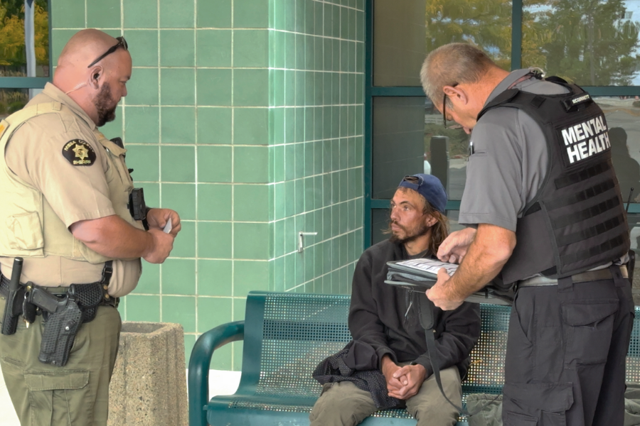 Sherriff's Deputy and Mental Health Professional offering help to unhoused man. 
