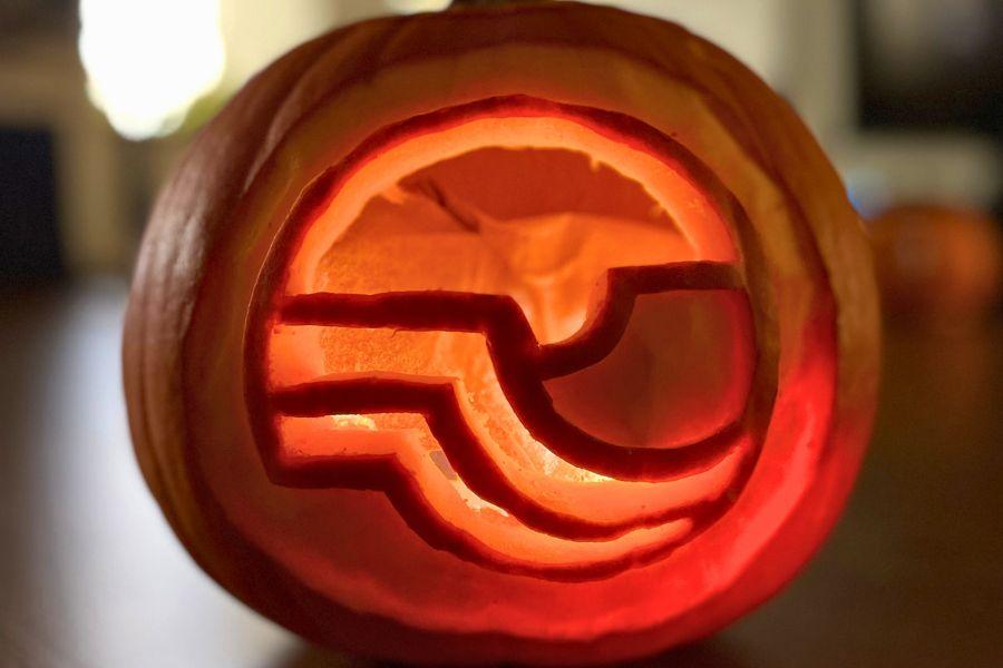 Mesa County logo carved into pumpkin that is glowing. 
