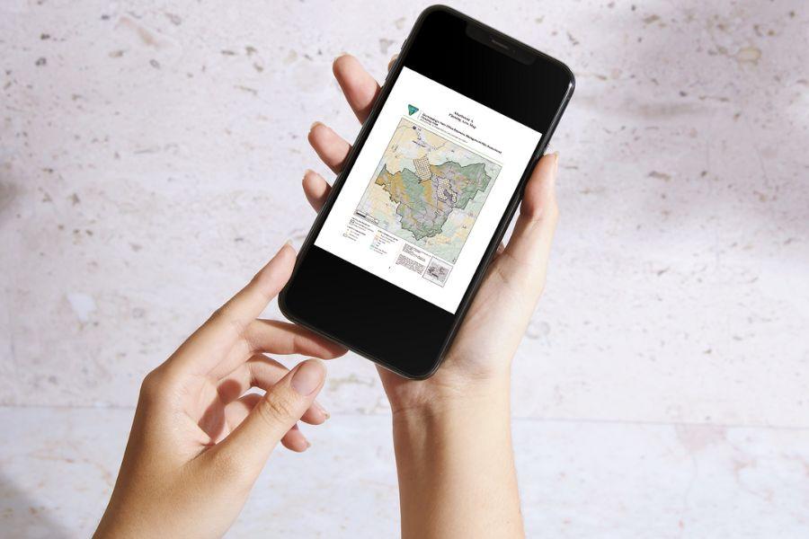 Hands holding smart phone displaying map.