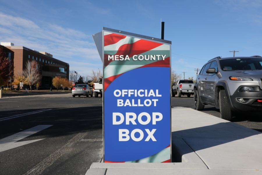Red, white, and blue ballot drop box reading, "Mesa County Official Ballot Drop Box," in white text.
