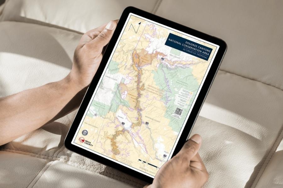Hands holding IPad displaying map. 
